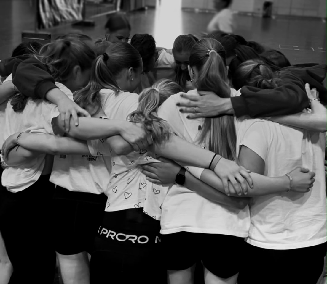 Tänzerinnen von Dancevolution stehen eng umarmt im Kreis zusammen